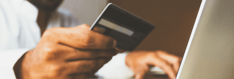 Young people with credit card standing next to the ATM to withdraw money