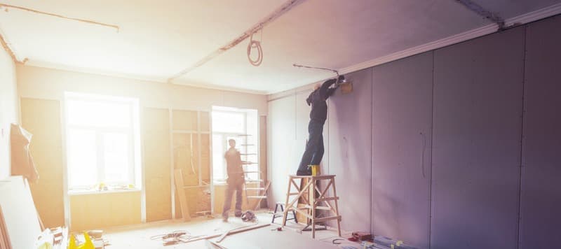 Workers are installing plasterboard (drywall) for gypsum walls in apartment is under construction, remodeling, renovation, extension, restoration and reconstruction.