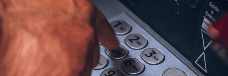 woman at the cash machine withdrawing mone
